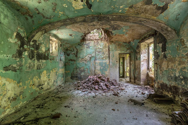 Interior shot of an abandoned building interior with green walls and collapsed ceiling - Foto, Imagem