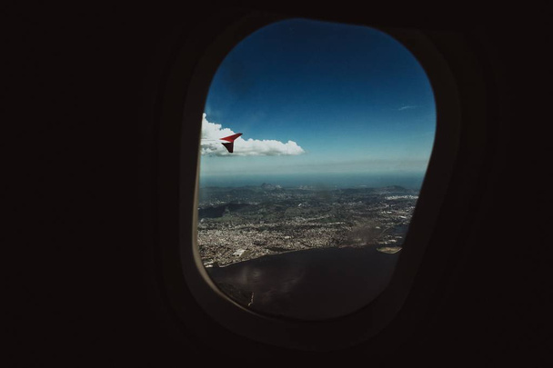 Vaakasuora laukaus taivas ja kaupunki, otettu lentokoneen porthole
 - Valokuva, kuva