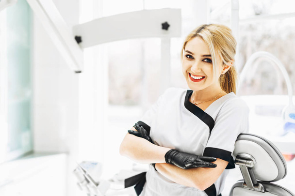 Portrait of the pretty young female dentist in a dental clinic. - 写真・画像