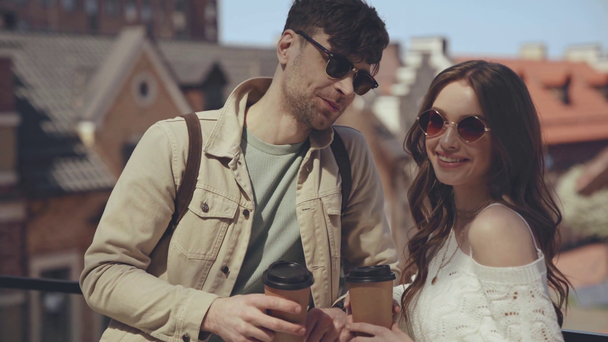 Skupienie na szczęśliwym mężczyźnie i kobiecie z papierowymi kubkami  - Materiał filmowy, wideo