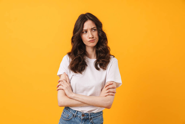 Sad displeased young woman posing isolated over yellow wall background. - Fotoğraf, Görsel