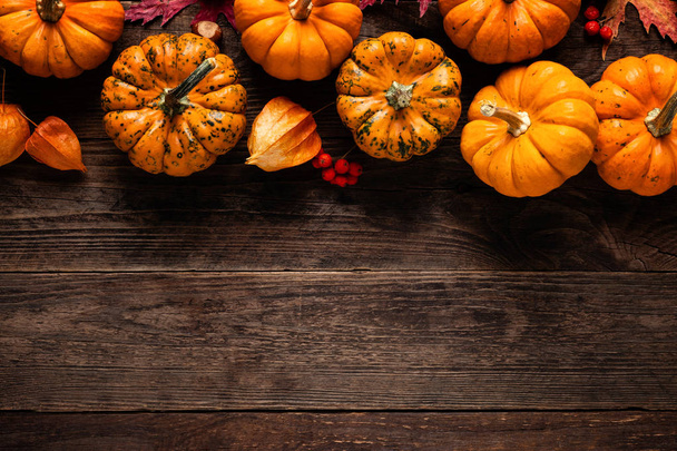 Autumn decorative pumpkins with fall leaves on wooden background. Thanksgiving or halloween holiday, harvest concept. Top view, copy space. Greeting card - Photo, Image