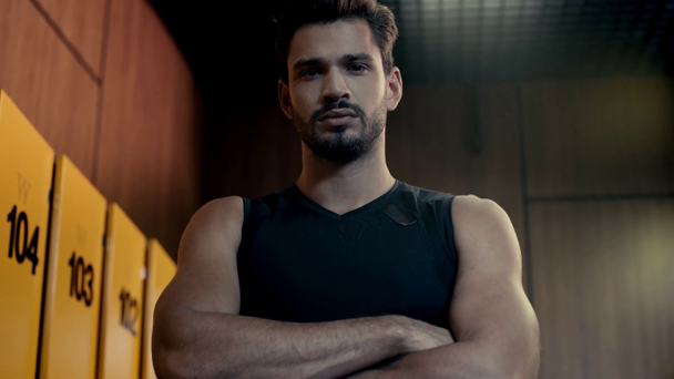sportsman with crossed arms in locker room  - Video, Çekim