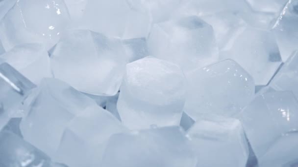 Макро знімок кубиків льоду з чистої води, яка тане повільним рухом на білому тлі. Концепція: чиста гірська джерельна вода, лід, коктейлі, свіжі та заморожені продукти
. - Кадри, відео