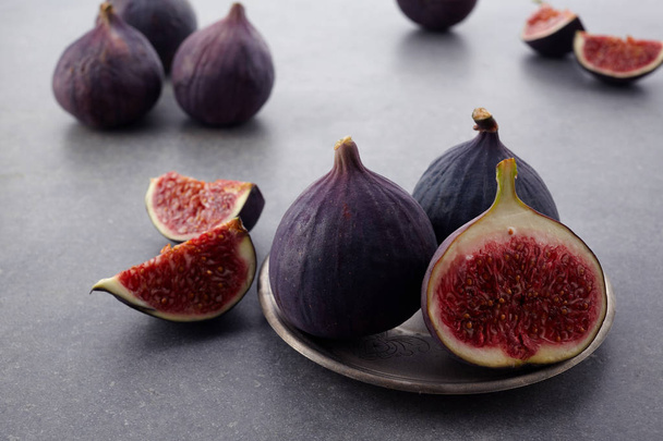 A few fresh figs in a bowl on an old dark background. - Zdjęcie, obraz
