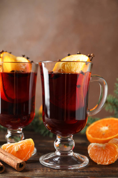 Glasses of tasty mulled wine with orange on wooden background, s - Foto, afbeelding