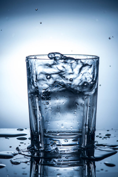 spatten van schoon water in een glas - Foto, afbeelding