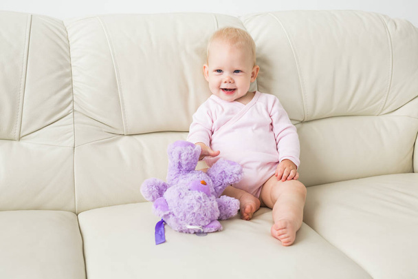Child, childhood and kids concept - Portrait of charming baby girl on the couch - Photo, Image