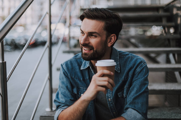 Positive man drinking mug of liquid during leisure - Foto, Imagen