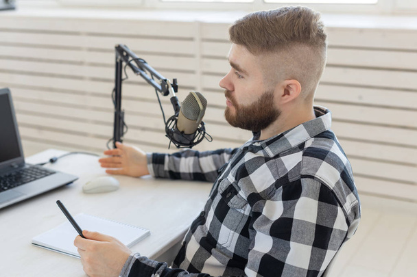 Radiomoderatorkonzept - Porträt eines lustigen gutaussehenden bärtigen Mannes, der vor dem Mikrofon sitzt - Foto, Bild