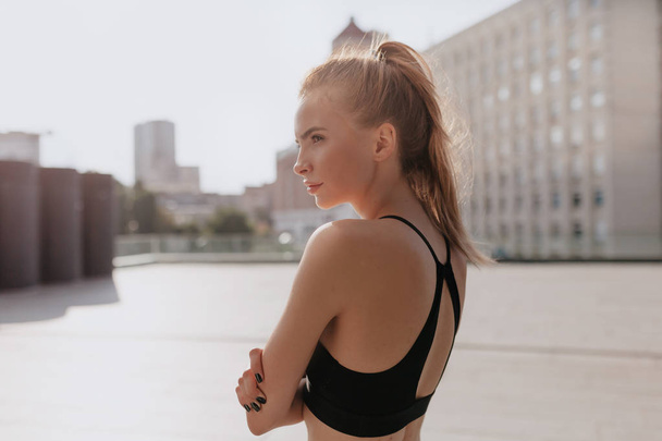 Zbliżenie portret z tyłu pasuje młoda kobieta na placu sportowym powietrza robi sport w porannym świetle słonecznym  - Zdjęcie, obraz
