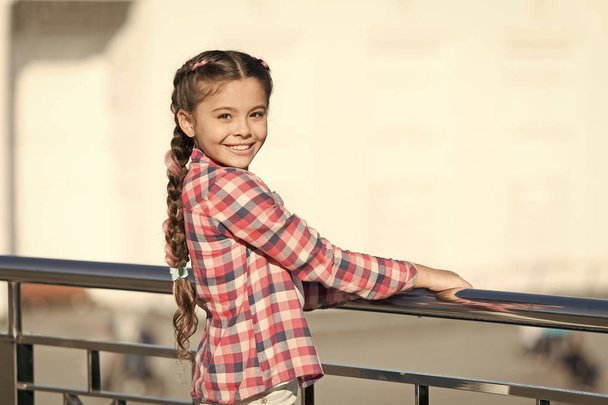 Fashionable clothes that make you feel relaxed. Happy small girl wearing fashionable plaid shirt. Fashionable look of little vogue model. Adorable fashionable child smiling on summer outdoor - Fotografie, Obrázek
