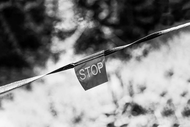 Contrastando lado claro e escuro com sinal de stop. Parada de inscrição. Foto em preto e branco
 - Foto, Imagem