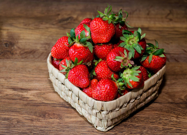 fresas maduras y sabrosas en un tazón de mimbre
 - Foto, imagen