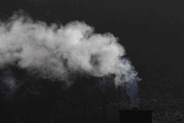 camino fumo bianco con uno sfondo scuro
 - Foto, immagini