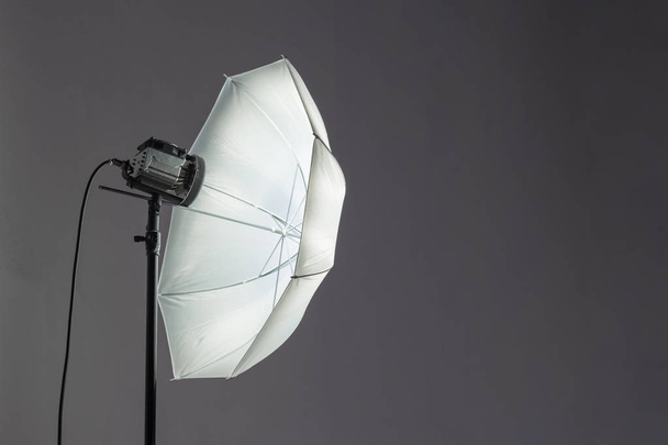 Parapluie projecteur dans un studio photo avec équipement d'éclairage sur l'espace de fond noir pour le texte et la publicité
 - Photo, image