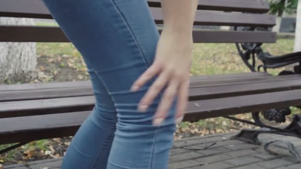 Woman standing up from bench feeling sharp knee pain in park, osteoarthritis, injury - Materiaali, video
