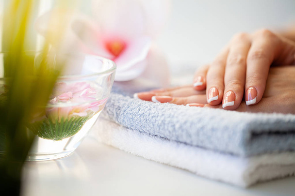 Beautiful womans nails with french manicure, in beauty studio - Zdjęcie, obraz