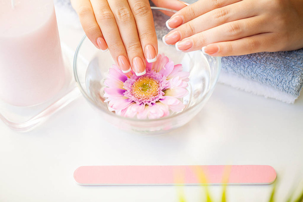 Beautiful womans nails with french manicure, in beauty studio - Photo, Image