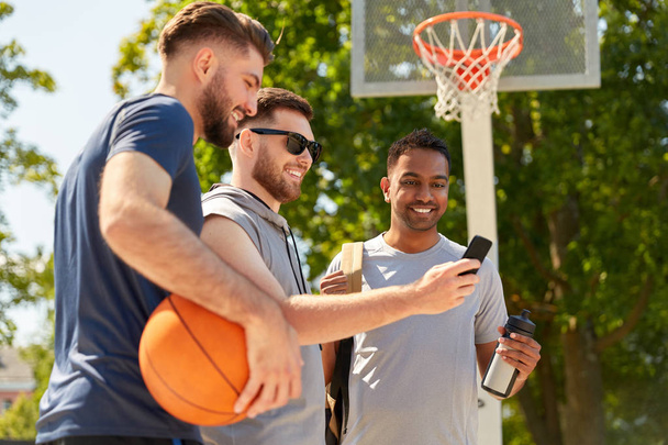 men with smartphone on basketball playground - Φωτογραφία, εικόνα