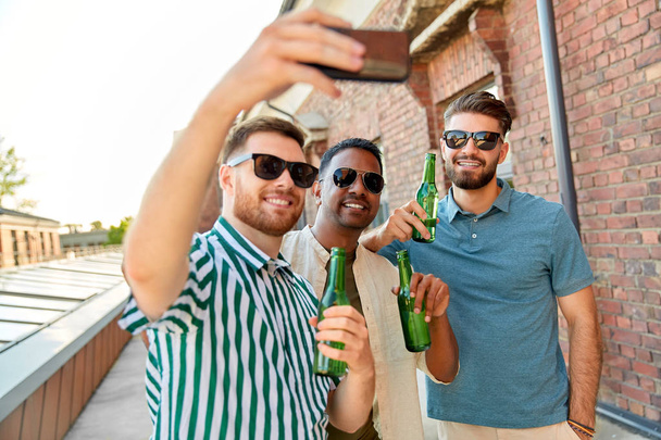 hombres bebiendo cerveza y tomando selfie por teléfono inteligente - Foto, imagen
