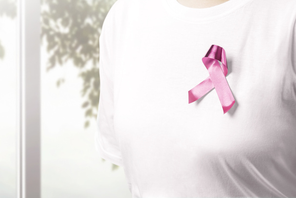 Woman in a white shirt with a pink ribbon with window background - Foto, Bild