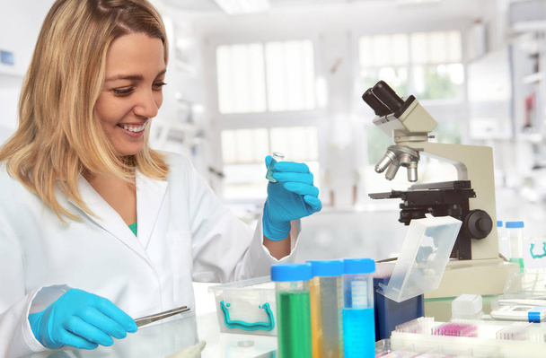 Female scientist in lab coat and protective gloves - Fotó, kép