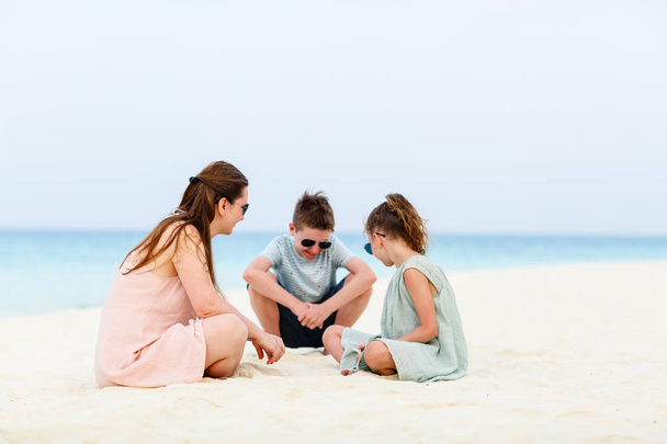 Family mother and kids enjoying tropical beach vacation - Foto, imagen