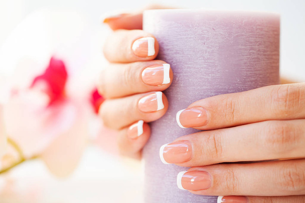 Beautiful womans nails with french manicure, in beauty studio - Photo, Image