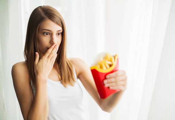 Frau misst Körpergewicht auf Waage mit ungesundem Junk Food - Foto, Bild