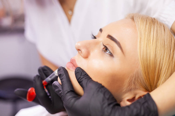 Aumento de labios en la Clínica de Cosmetología. hermosa mujer consiguiendo belleza inyección para labios
 - Foto, Imagen