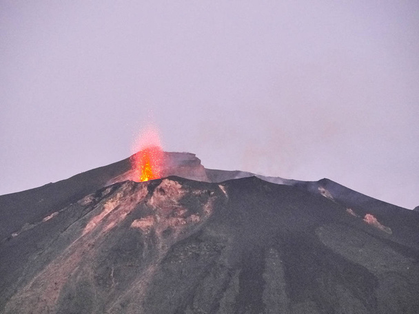 Shot of the eruption with magma, explosions, smoke and lapilli coming out from the volcano - Photo, Image