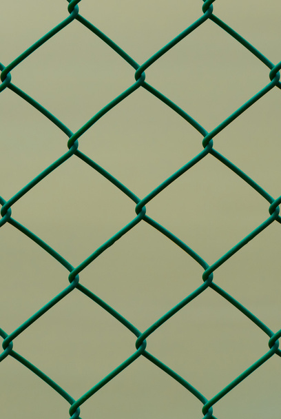 Cerca de alambre verde aislada sobre fondo marrón, patrón vertical
 - Foto, Imagen