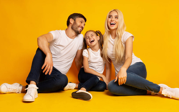 Vanhemmat ja tytär nauraa istuu lattialla Studio
 - Valokuva, kuva