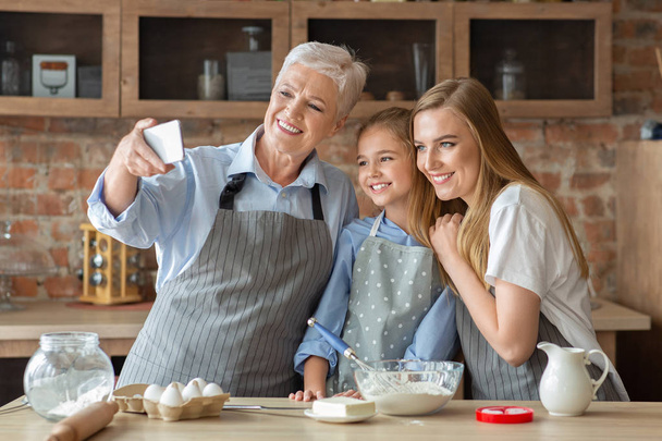 Női család figyelembe selfie a mobiloddal főzés közben együtt - Fotó, kép
