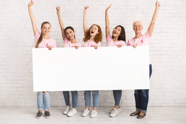 Multiethnic kobiet noszenie Pink T-shirty Holding White Board Indoor, makieta - Zdjęcie, obraz