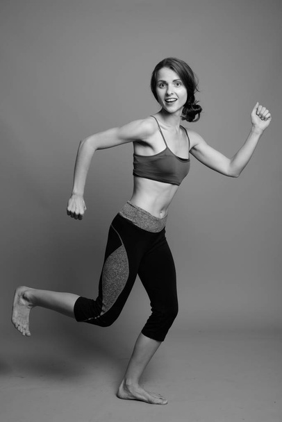 Junge schöne Frau bereit für Fitnessstudio vor grauem Hintergrund - Foto, Bild