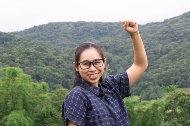 Asiática jovem mulher sorrir e levantar os braços com um olhar de sucção
 - Foto, Imagem