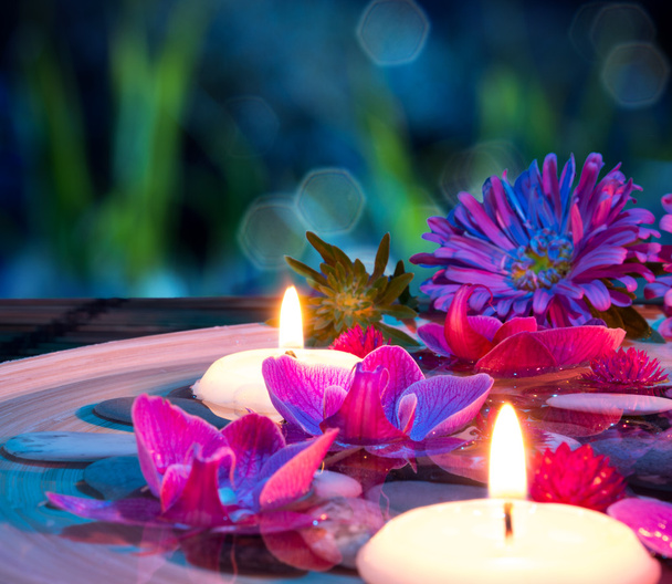 Plato spa con 2 velas flotantes, orquídea en la estera
 - Foto, imagen