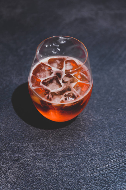 orange spritz cocktail glass with ice on dark concrete  - Фото, изображение
