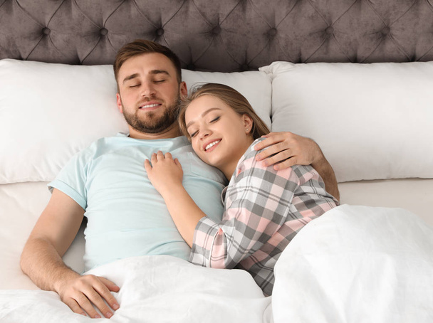 Young couple sleeping together in bed at home - Photo, Image
