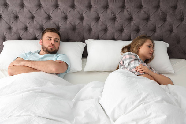 Молодая пара с проблемами отношений в постели дома
 - Фото, изображение