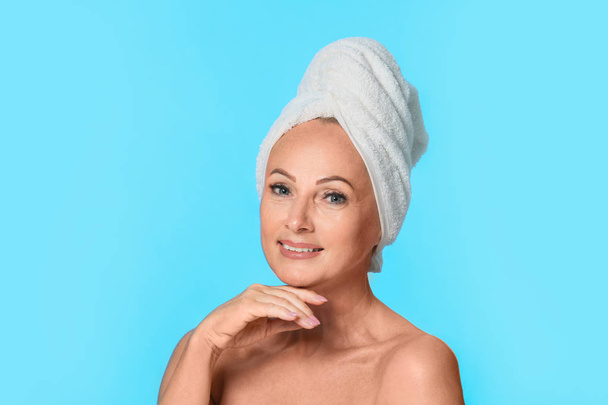 Portrait of beautiful mature woman with perfect skin on light blue background - Foto, immagini