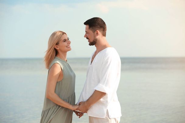 Happy romantic couple spending time together on beach - Photo, Image
