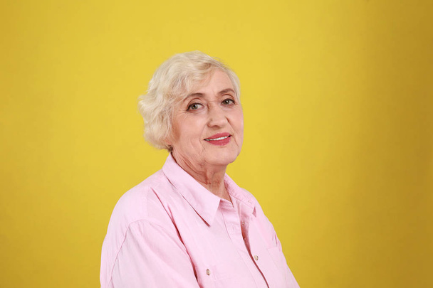 Senior woman in casual outfit on yellow background - Φωτογραφία, εικόνα