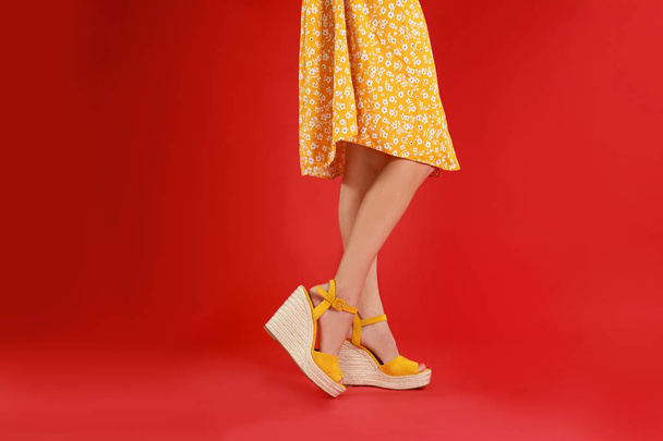 Woman in stylish shoes on red background - Foto, imagen