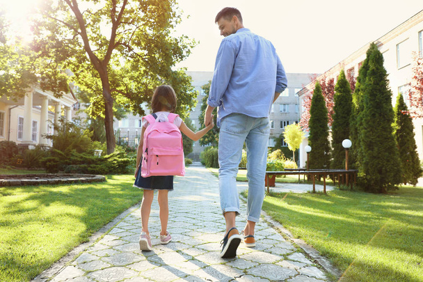 Father taking his little child to school through park - Valokuva, kuva
