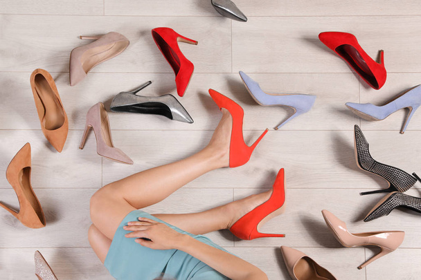 Woman and different stylish shoes on wooden floor, top view - Photo, image
