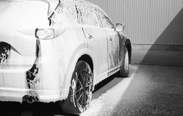 Luxury automobile covered with foam at car wash - Φωτογραφία, εικόνα
