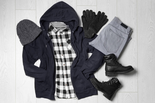Flat lay composition with winter clothes and boots on white wooden background - Foto, afbeelding